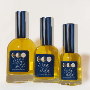 Three bottles of 'Wild Child' perfume with blue labels on a white background