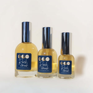 Three bottles of Rock Creek cologne on a white background