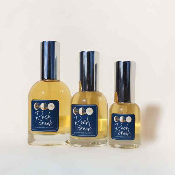 Three bottles of Rock Creek cologne on a white background