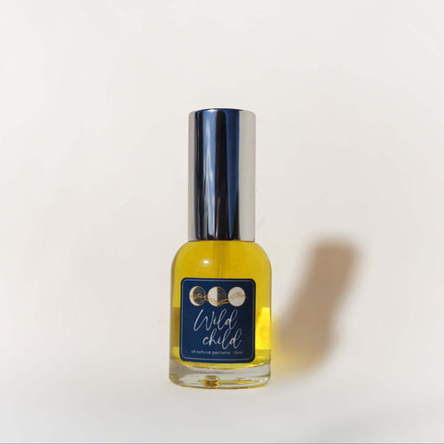 Bottle of 'Wild Child' perfume on a white background with a blue label
