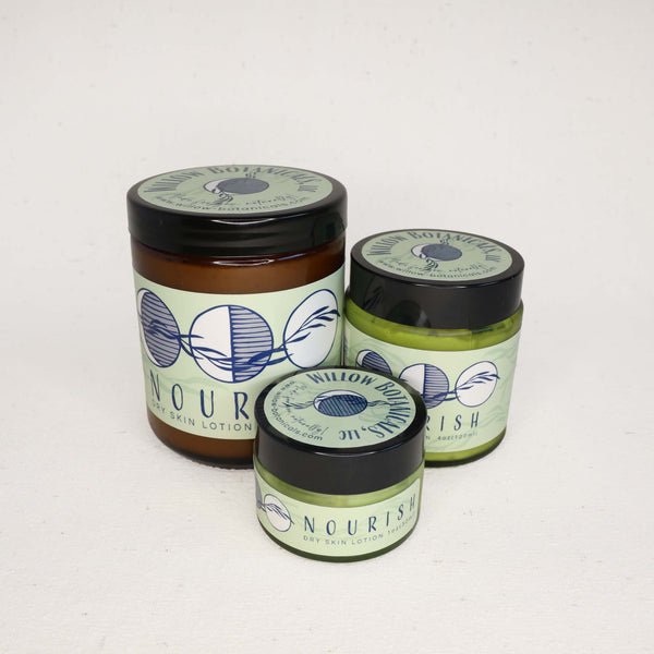 Three jars of Nourish Dry Skin Lotion on a white background